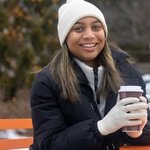 Prina, healthshift user smiling outdoors holding a coffee