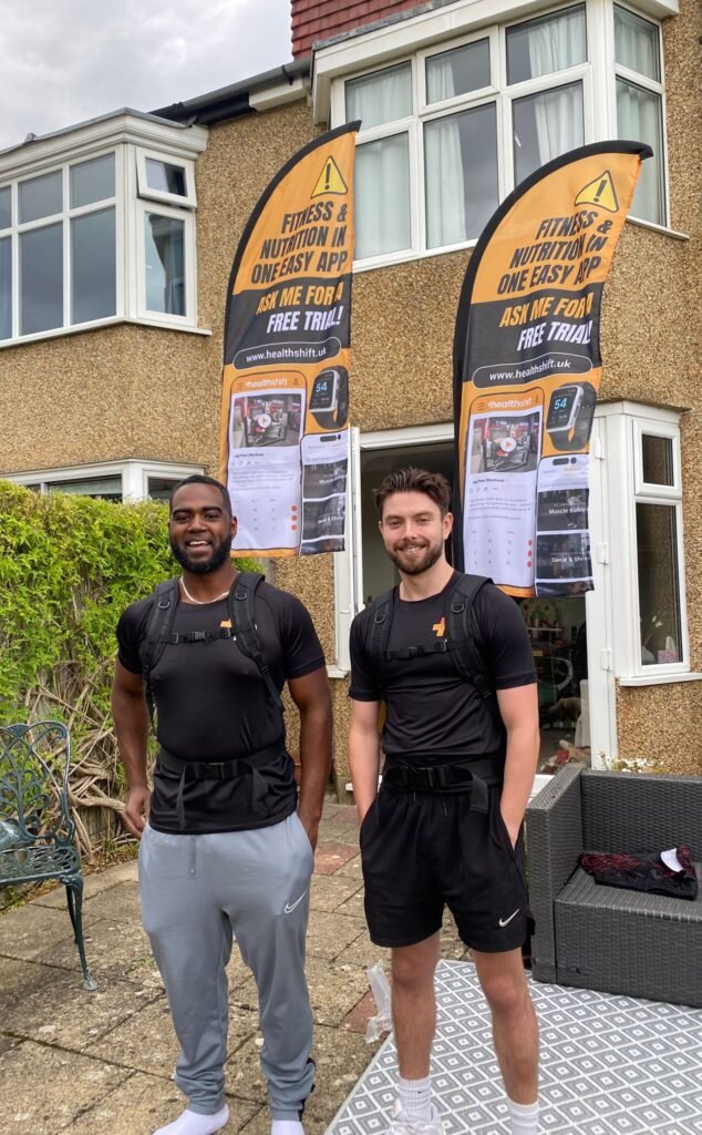 healthshift founders standing outside with branded flags during launch setup